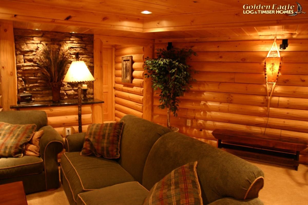 brown leather sofa in basement with log walls