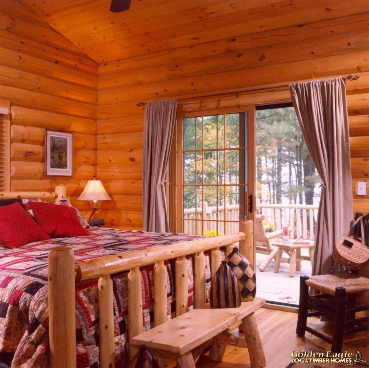 log four post bed in cabin bedroom with glass door to patio in background