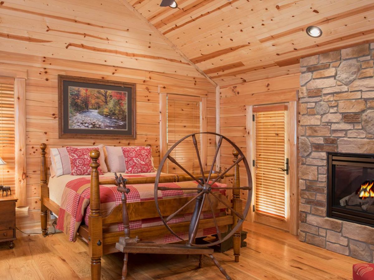 spinning loom on end of bed in log cabin bedroom