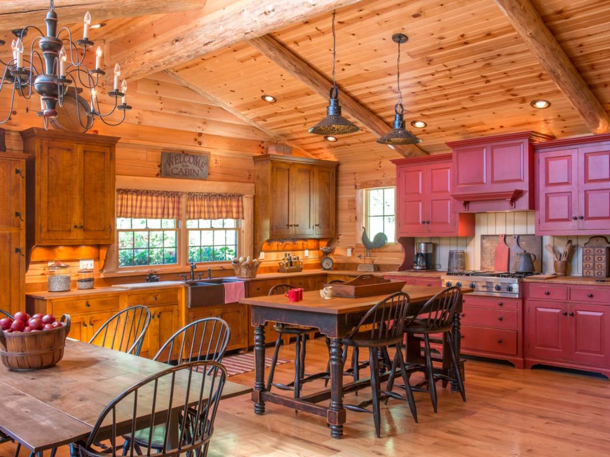 red cabinets in kitchen with wood table in center of room
