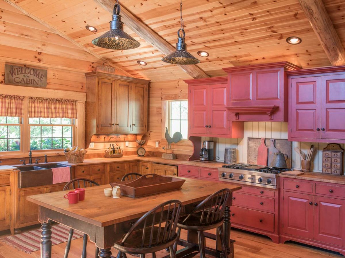 log cabin kitchen with wall of red cabinets and wall of wood cabinets