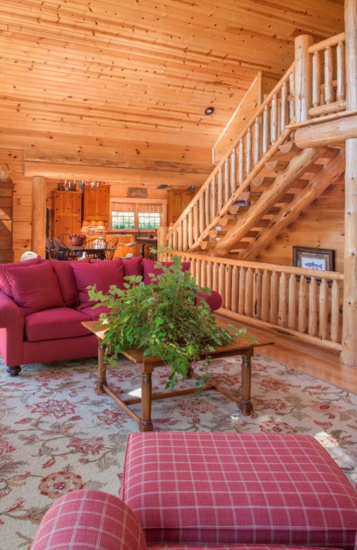 log stairs to loft and basement on right with red sofa in front of wood coffee table
