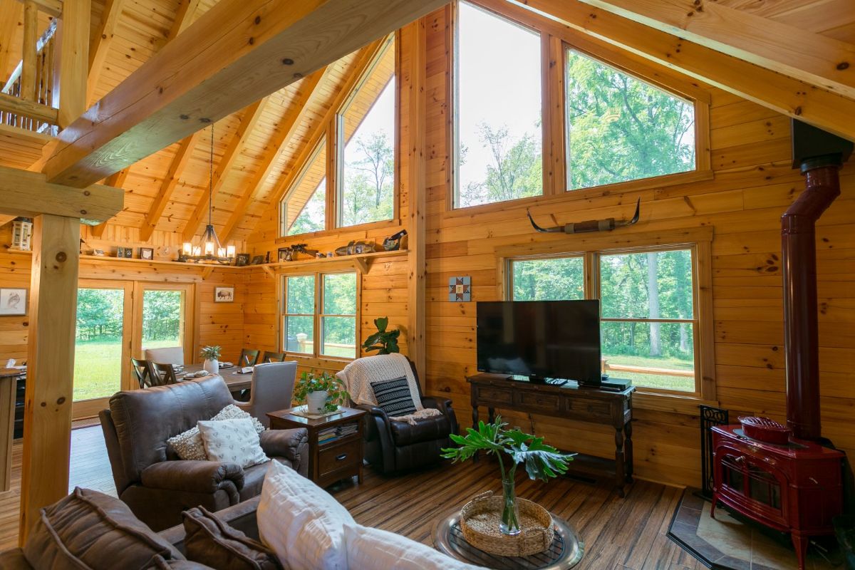 log cabin great room with wall of windows in living room