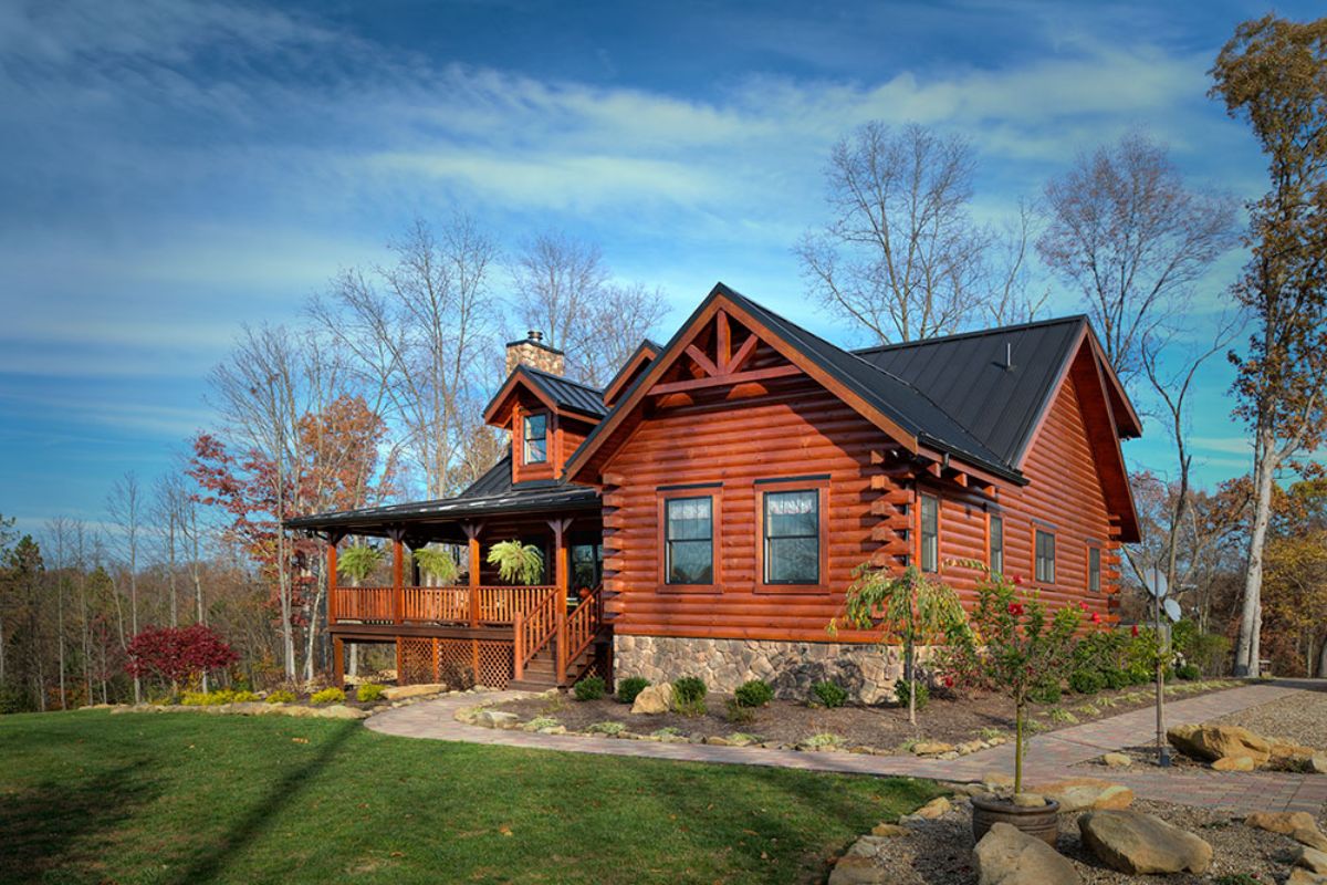 log cabin with gravel walkway and porch on front