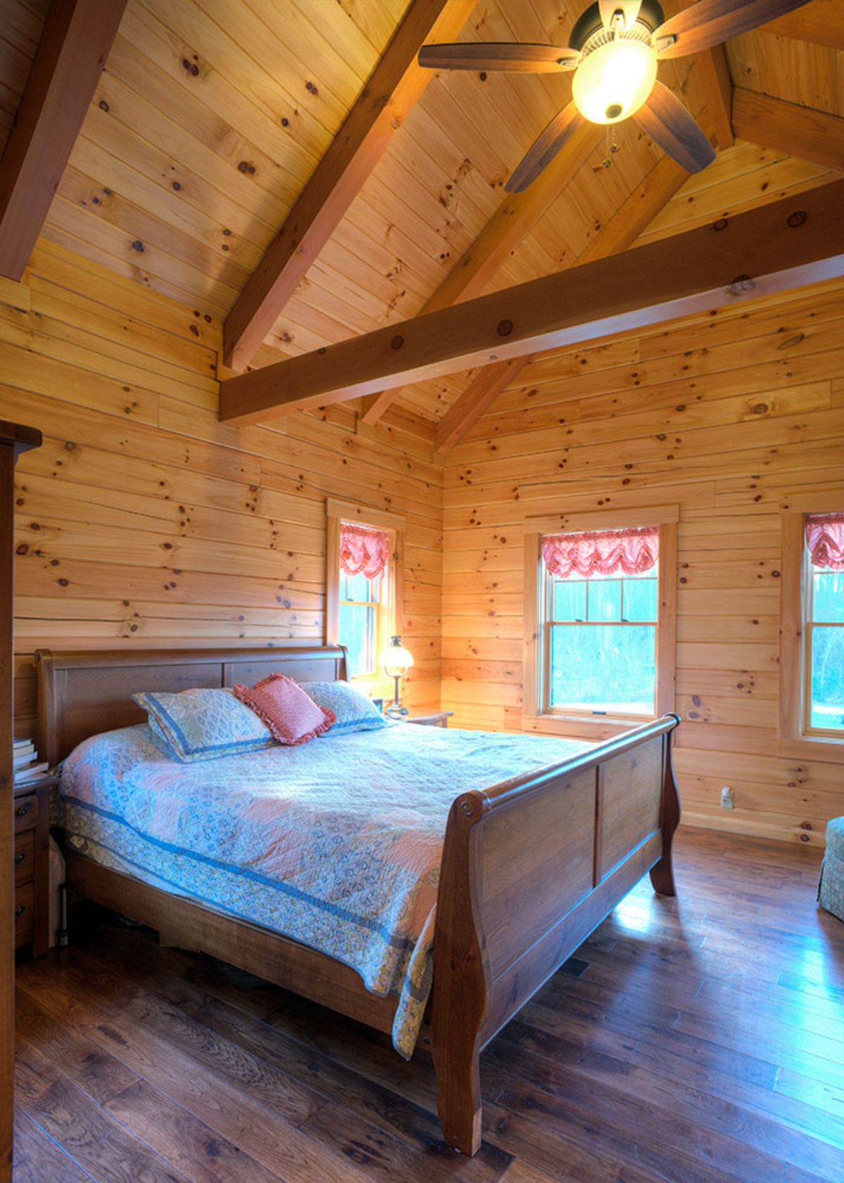 wood bed frame with light white comforter in log cabin