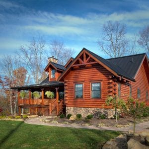 log cabin with gravel walkway and porch on front