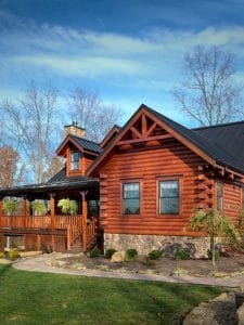log cabin with gravel walkway and porch on front