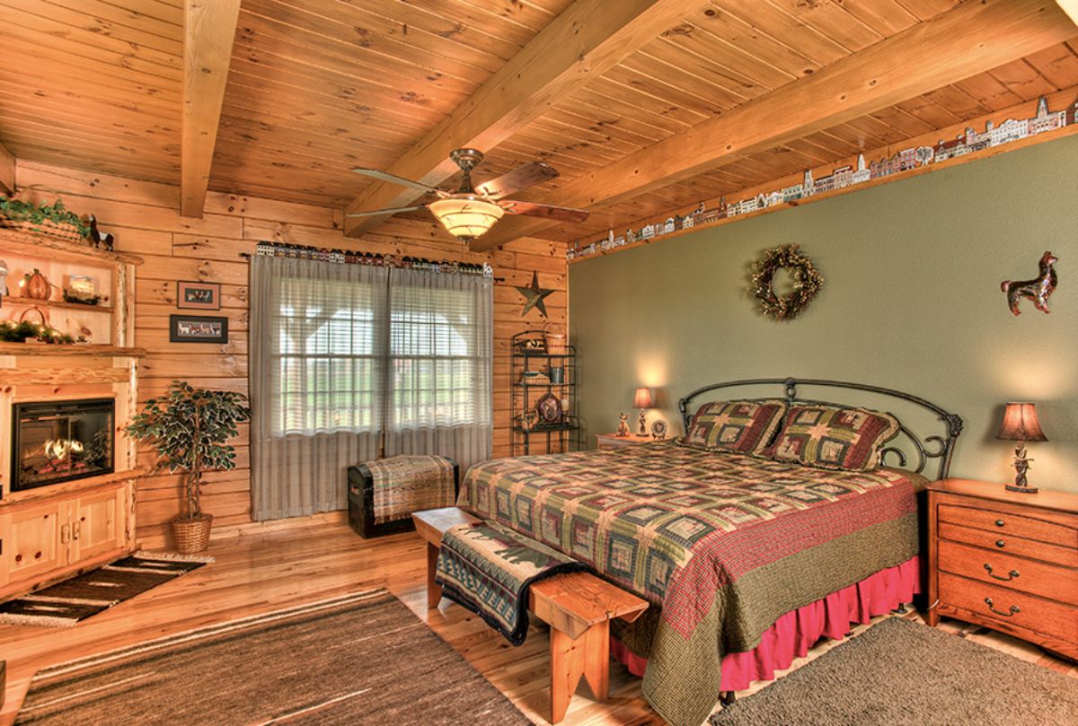 green wall behind bed in log cabin bedroom