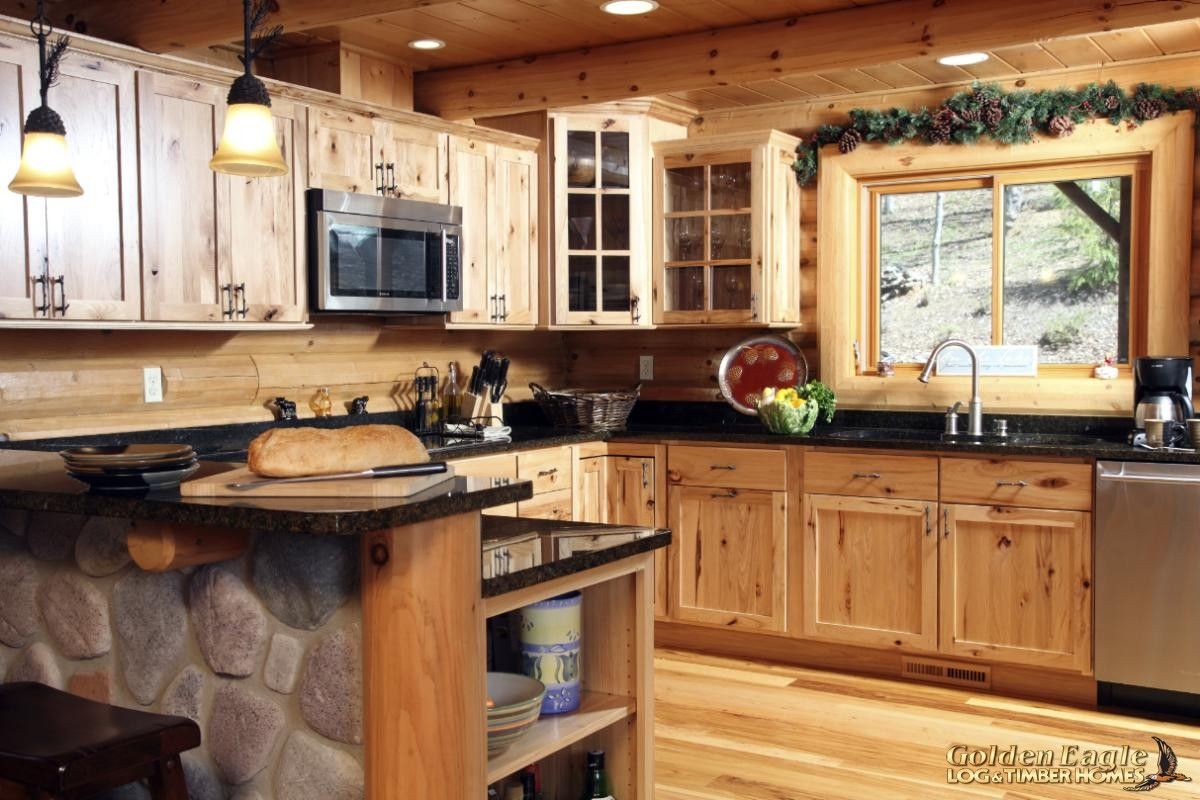 wood cabinets in log cabin kitchen with black countertops