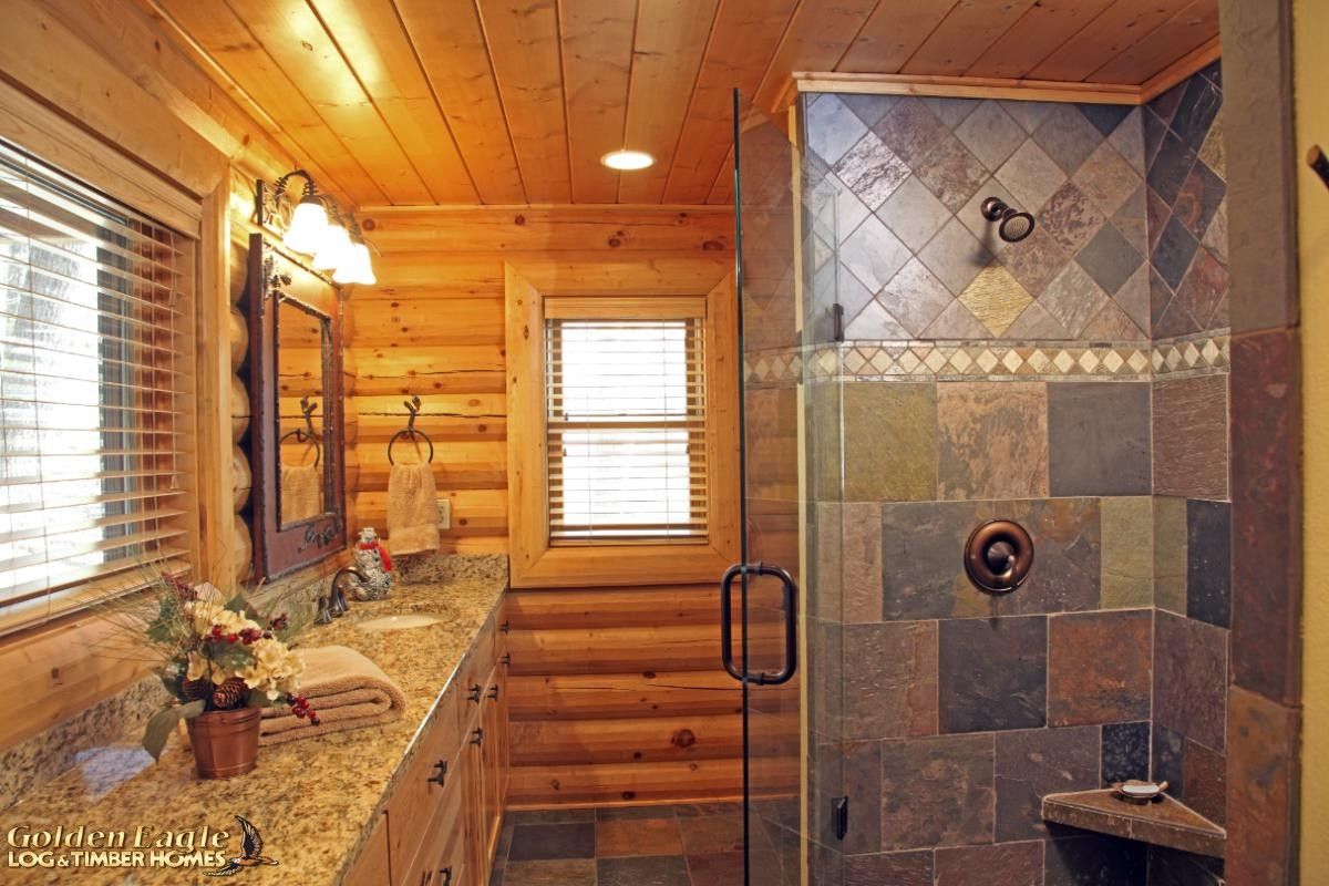 tile shower on back right wall of bathroom with log walls