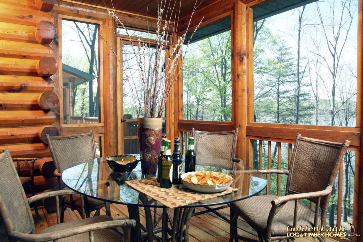 table with chairs on deck of log cabin
