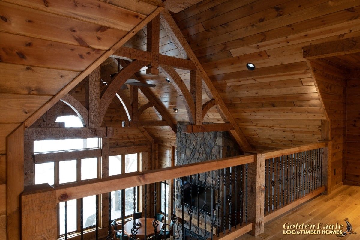 view of wood beams and top of stone fireplace chimney from loft