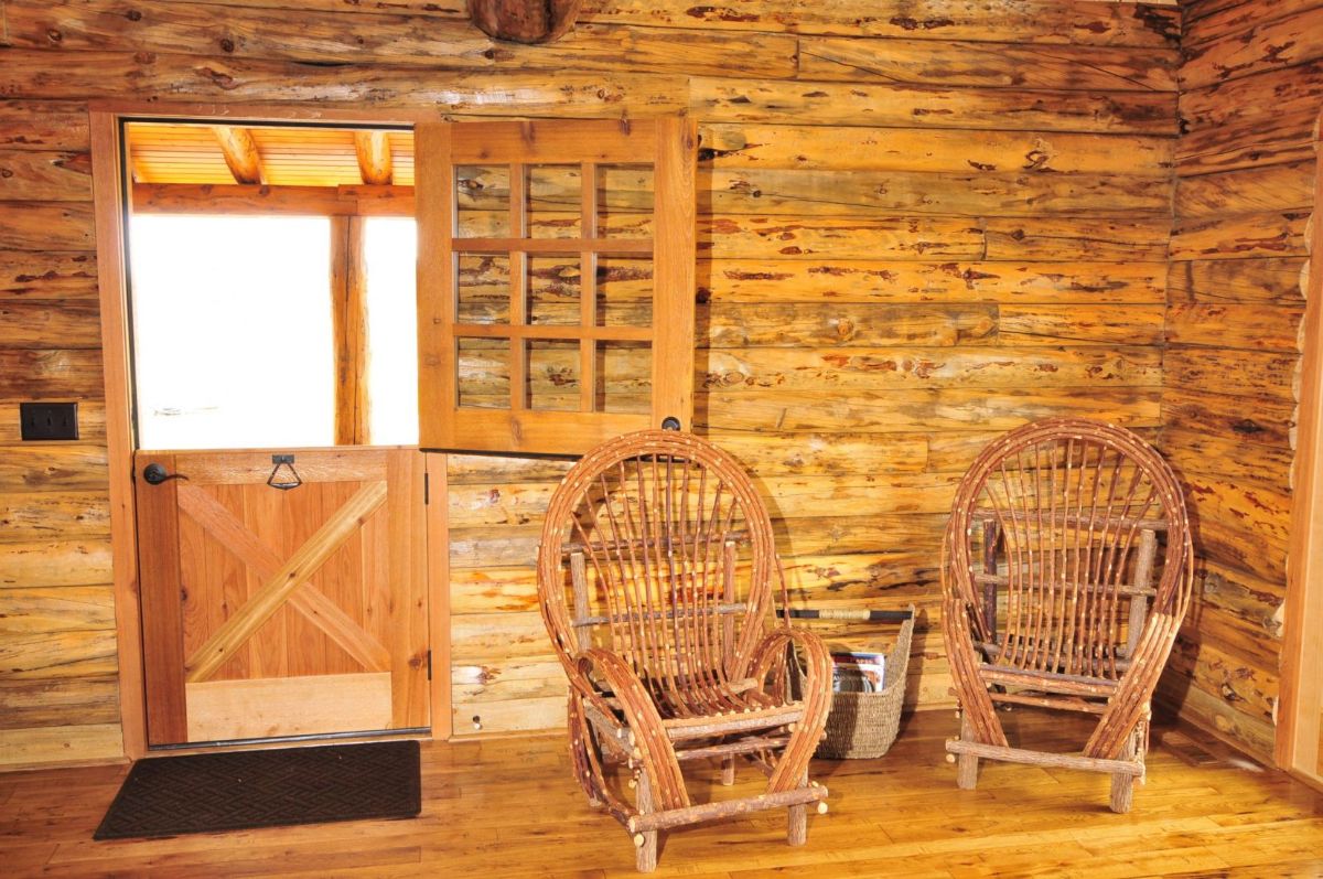 Dutch door of log cabin by two rocking chairs