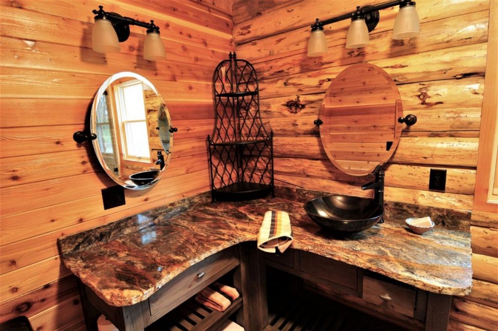 bathroom with corner vanity and two oval mirrors