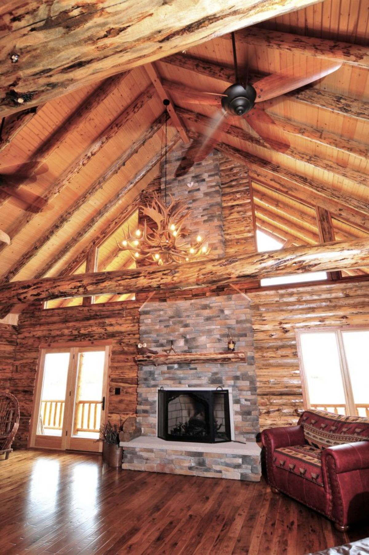 stone chimney against wall of log cabin great room