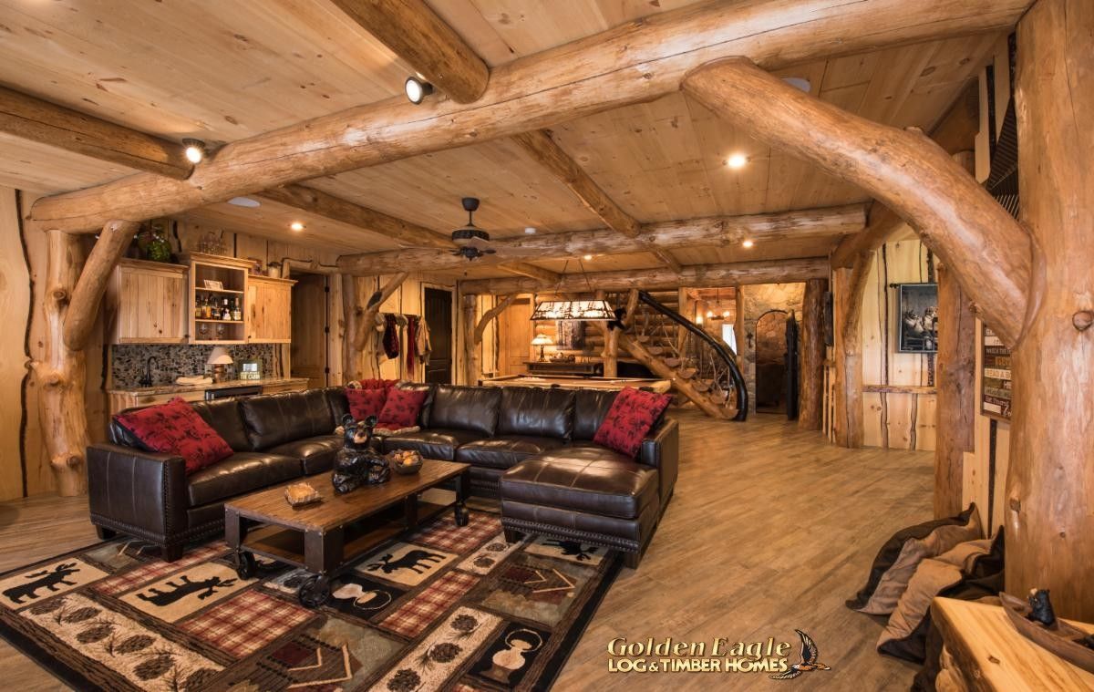 brown leather sofa on colorful rug in log basement