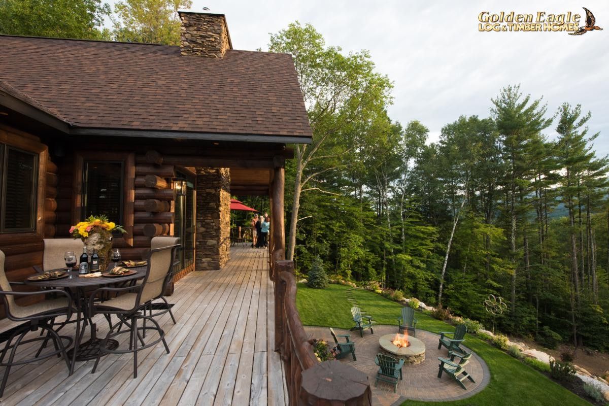 back deck of log cabin with table and chairs