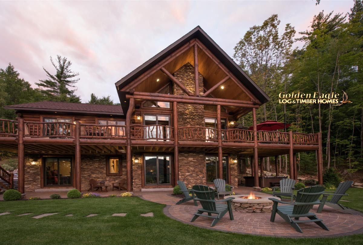 back of log cabin with deck above walkout basement and wall o windows