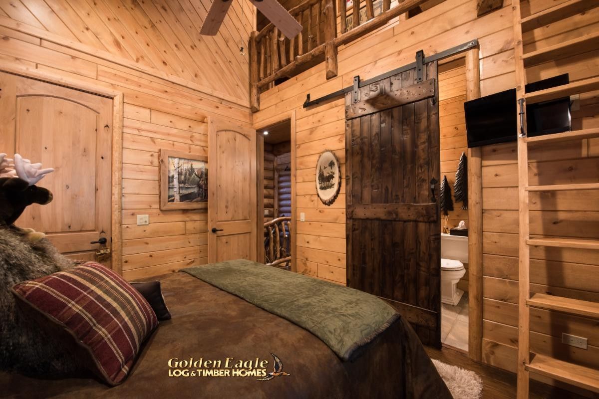 ladder against wall with barn door in front of bed