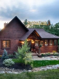 dark wood log cabin in rock landscaping