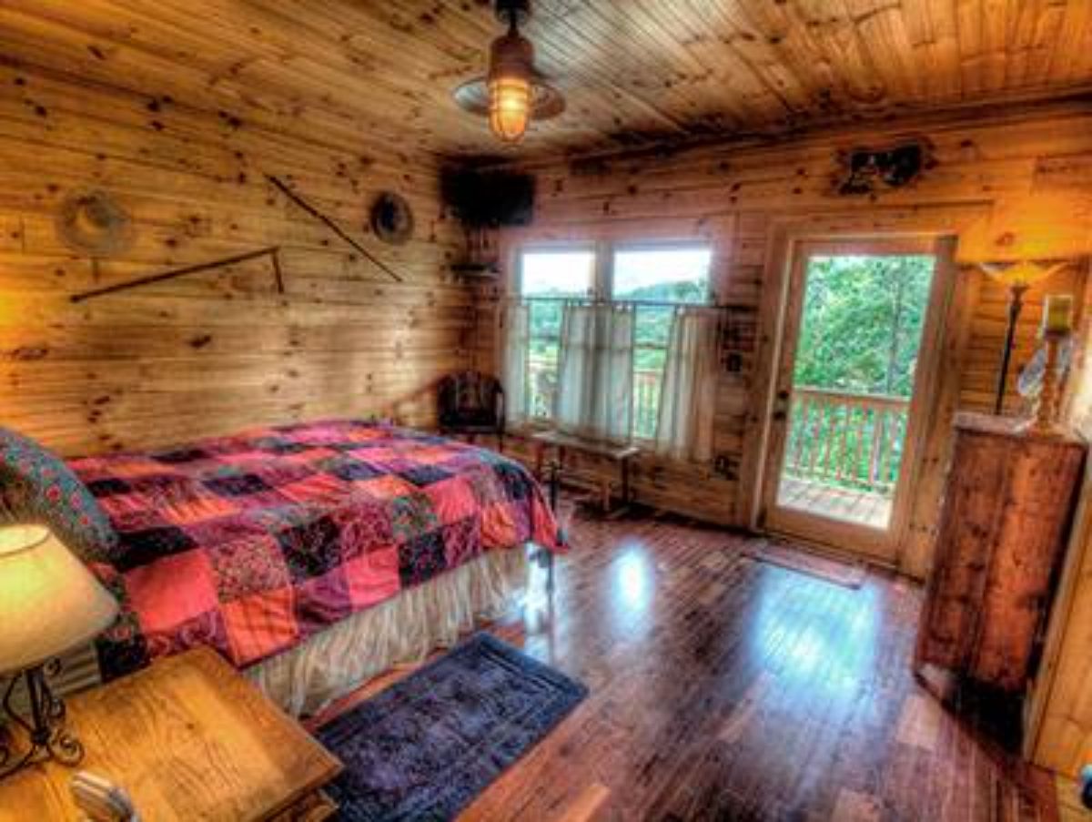 bufalo plaid blankets on bed in log cabin bedroom with door off back side