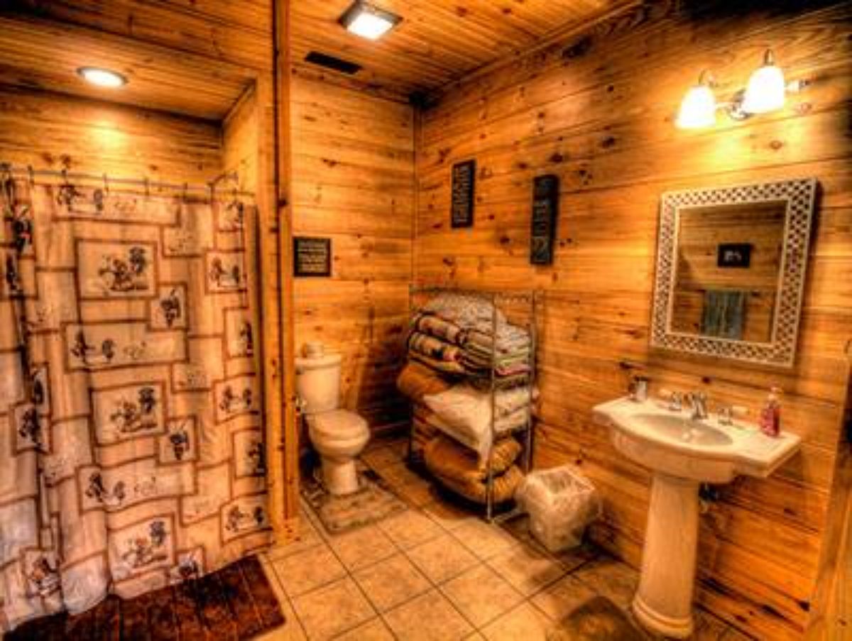 rustic shower curtain in bathroom with white pedestal sink