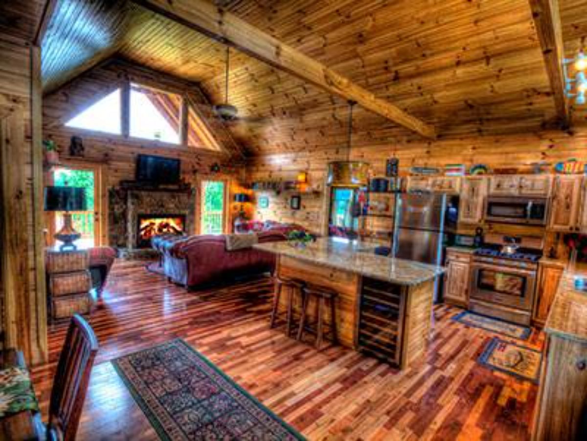 island in middle of kitchen with dark wood stained floors and ceiling