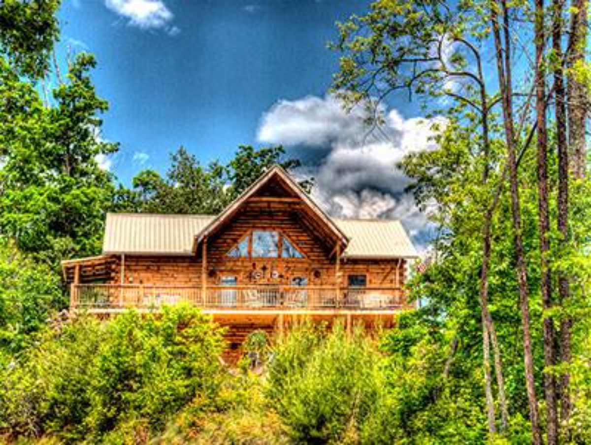 log cabin behind green trees and shrubs