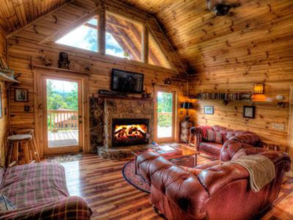 cream and red sofa with fireplace against wall beneath trapezoid windows