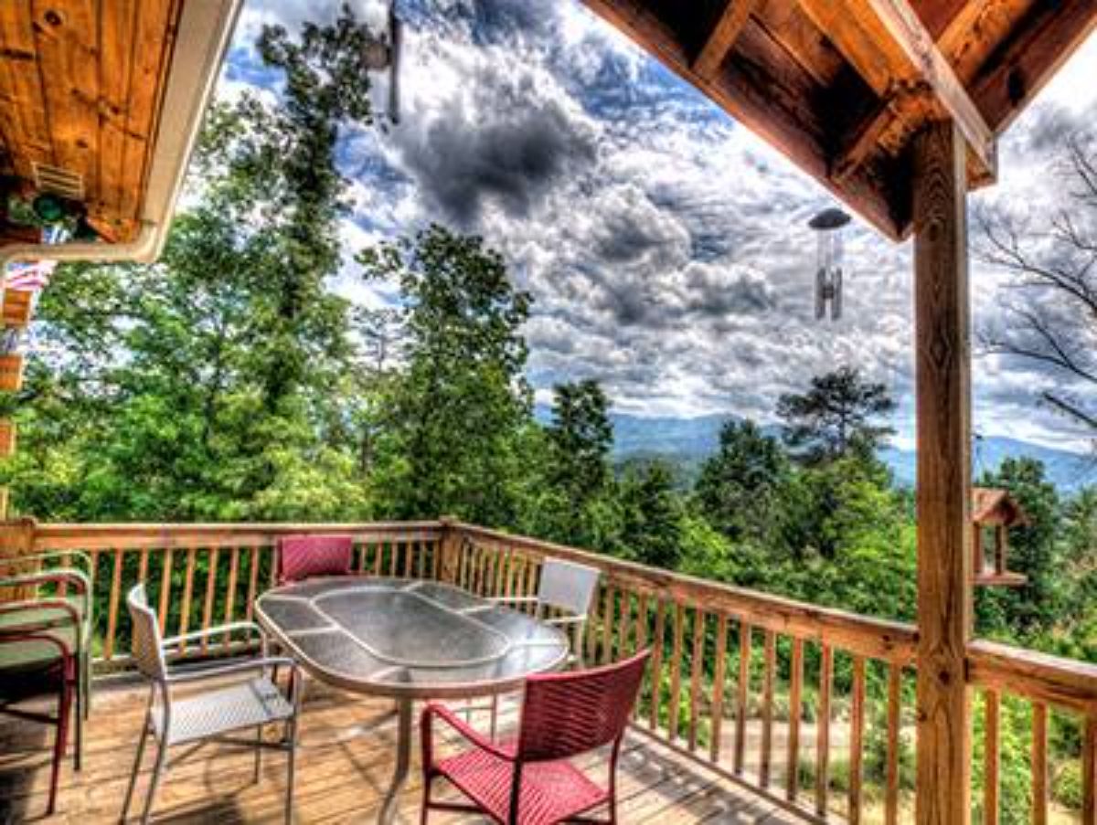 glass table on open porch of log cabin deck