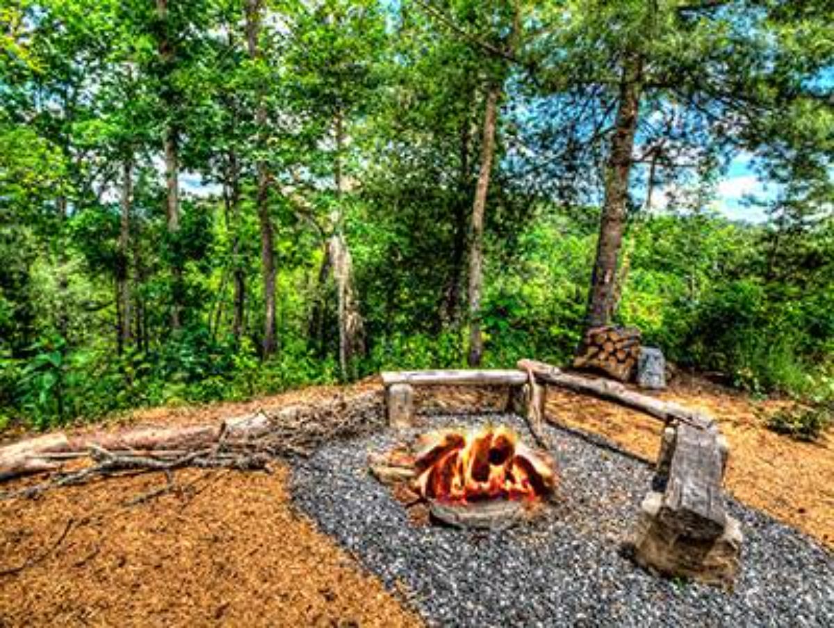 firepit on gravel path with rustic log fence in background