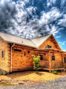log cabin with light wood and light roof against colorful cloudy sky