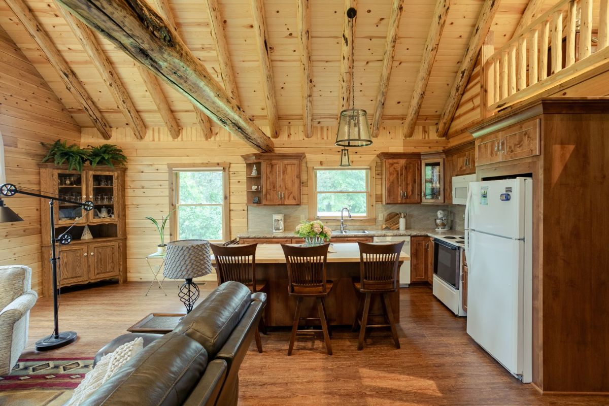 view into kitchen with white refrigerator on right of log cabin kitchen