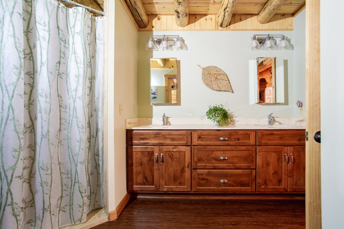 wod vanity below two mirrors with shower curtain on left in bathroom