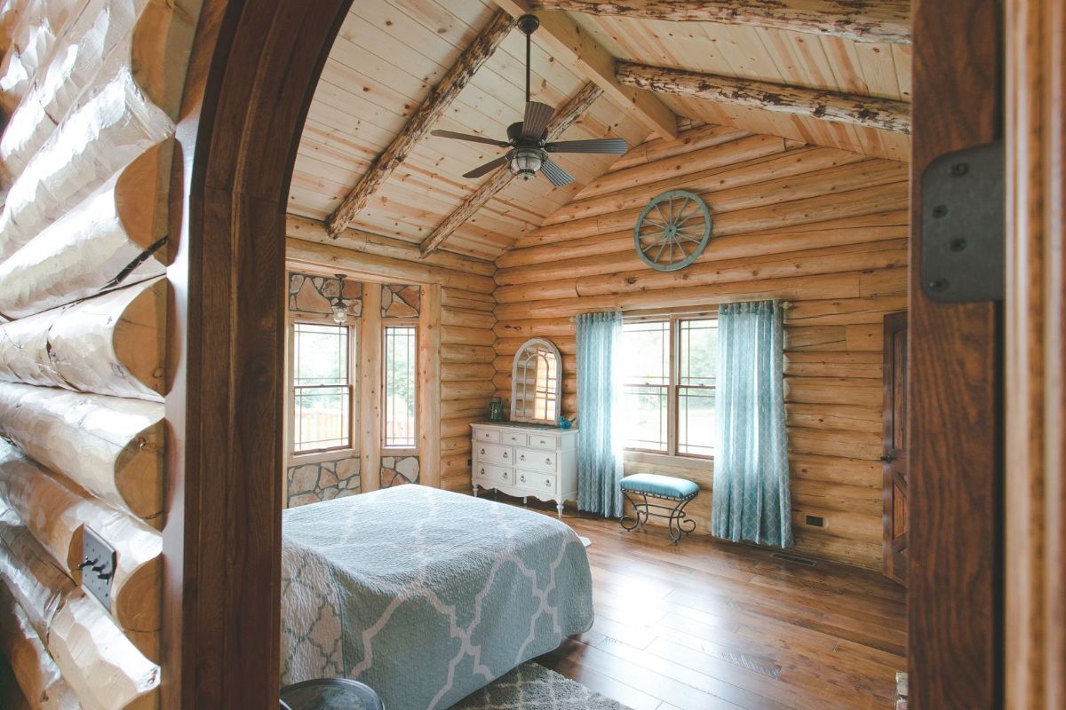 view into bedroom from arched door with blue curtains on windows