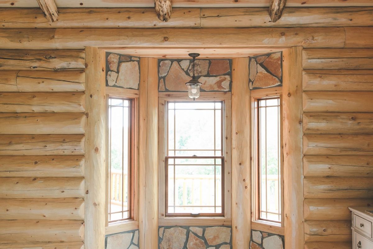 private bay window beside dresser in log cabin bedroom