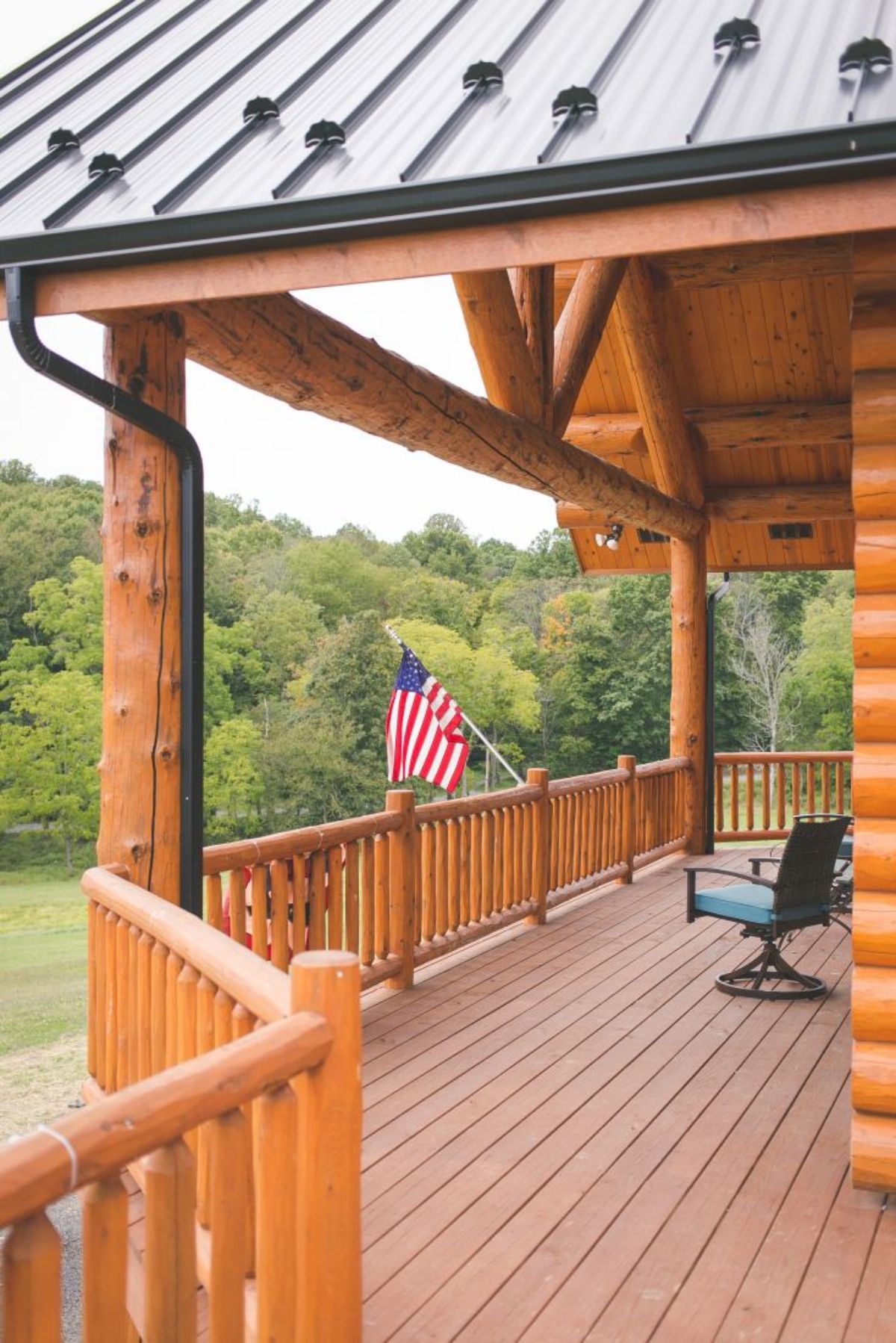 deck with partial roof covering and chair beside american flag hanging off deck