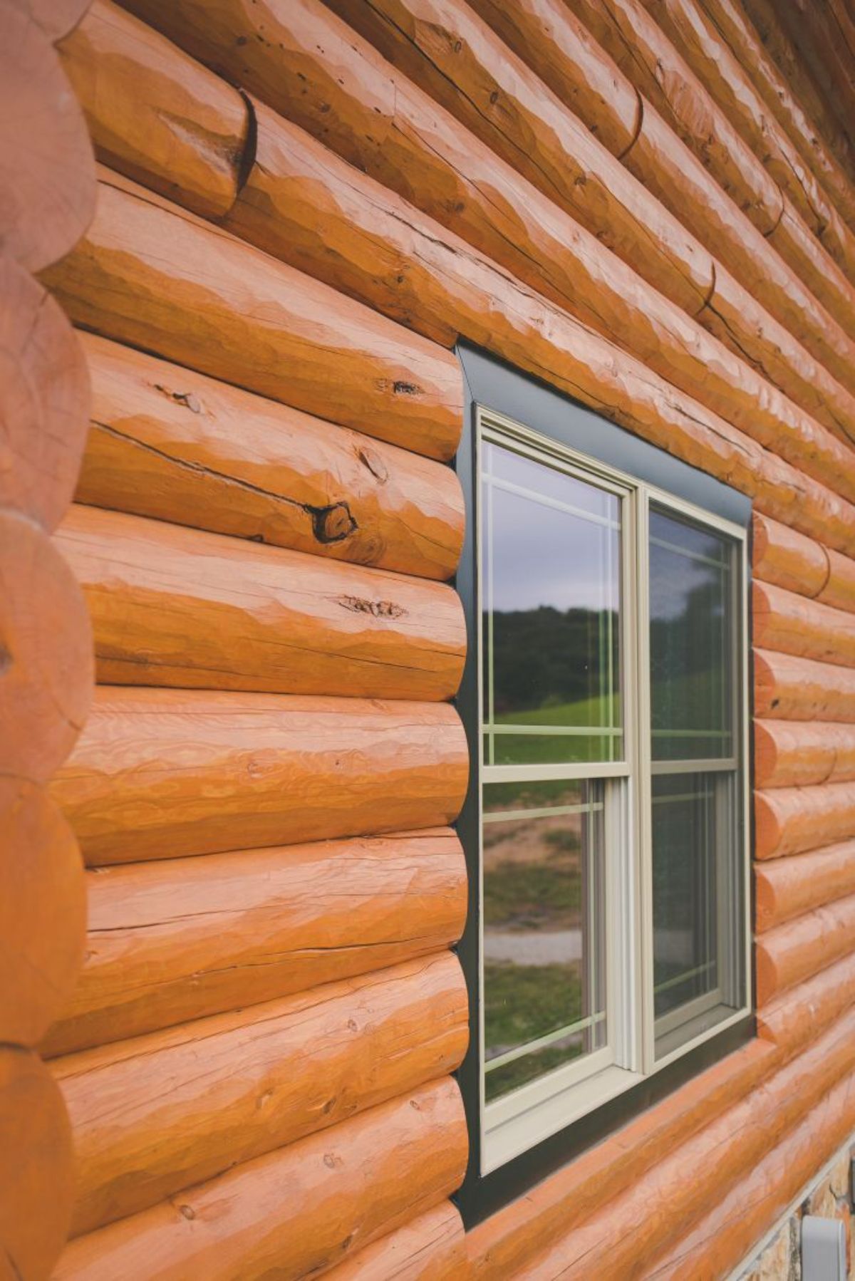 log siding on cabin with dark trim around window