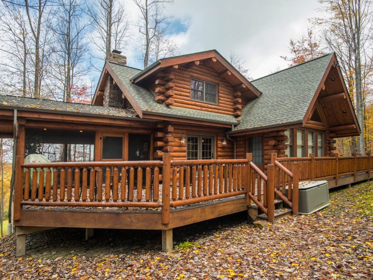 side of log cabin with covered porch and open deck