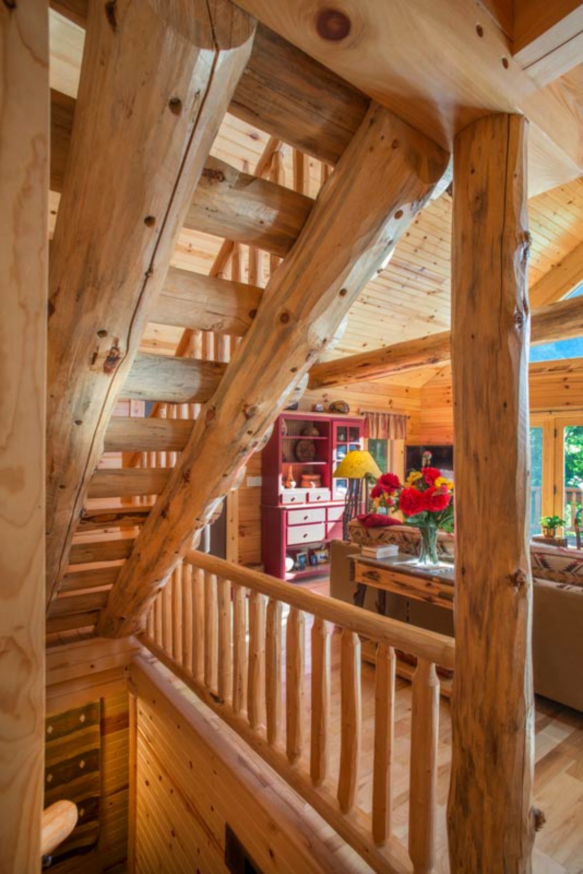 log stairs leading to second floor and basement inside log cabin