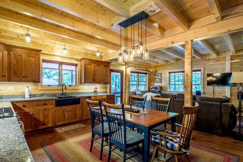 dining table in foreground of log cabin kitchen