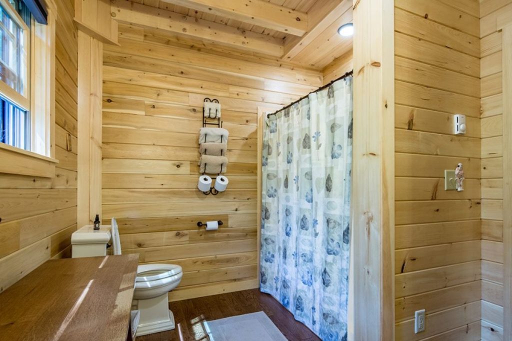 light wood walls in bathroom with rustic shower curtain