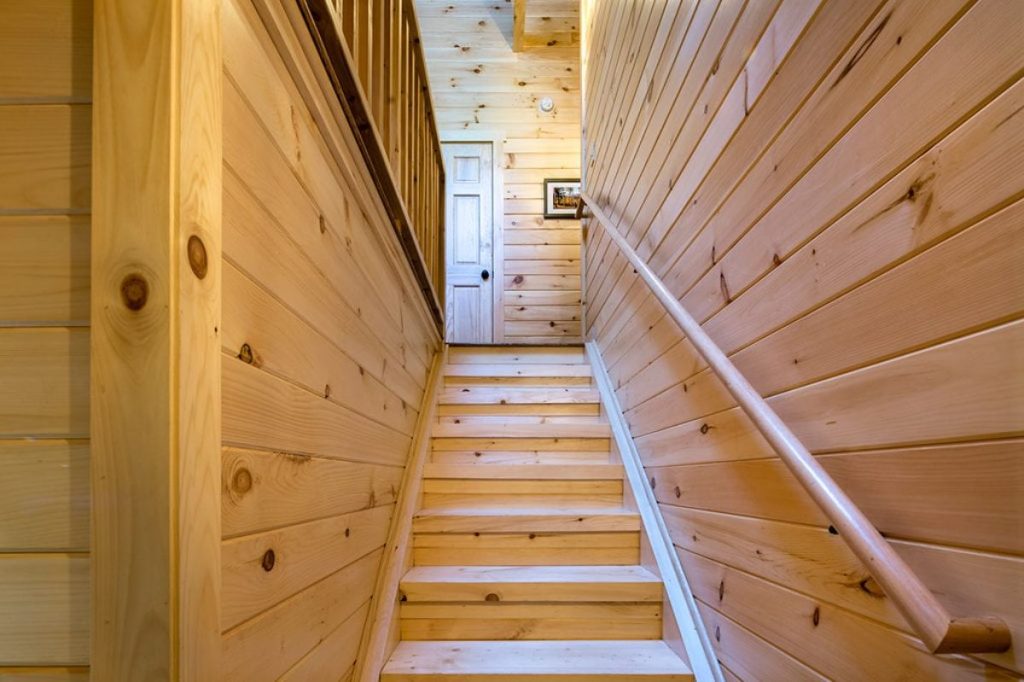 light wood stairs and walls leading to upper level of home