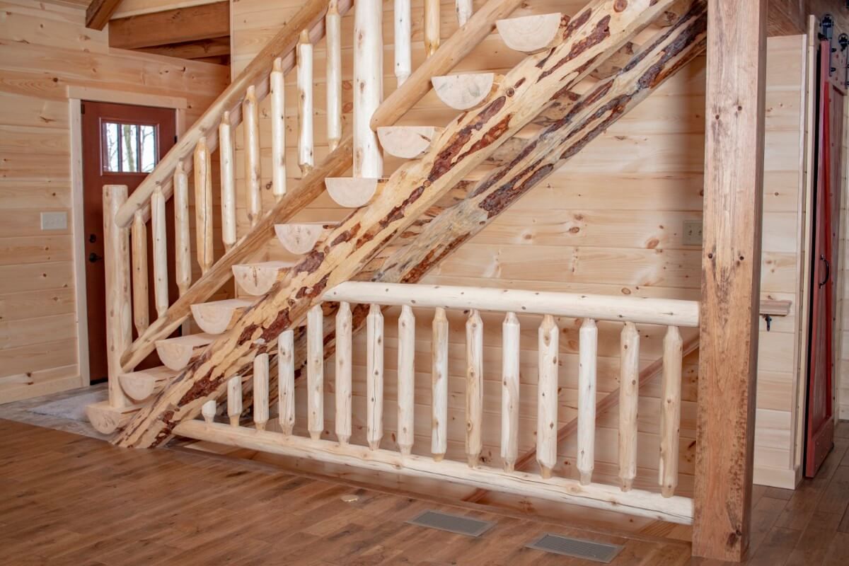 light wood stairs to loft near red front door