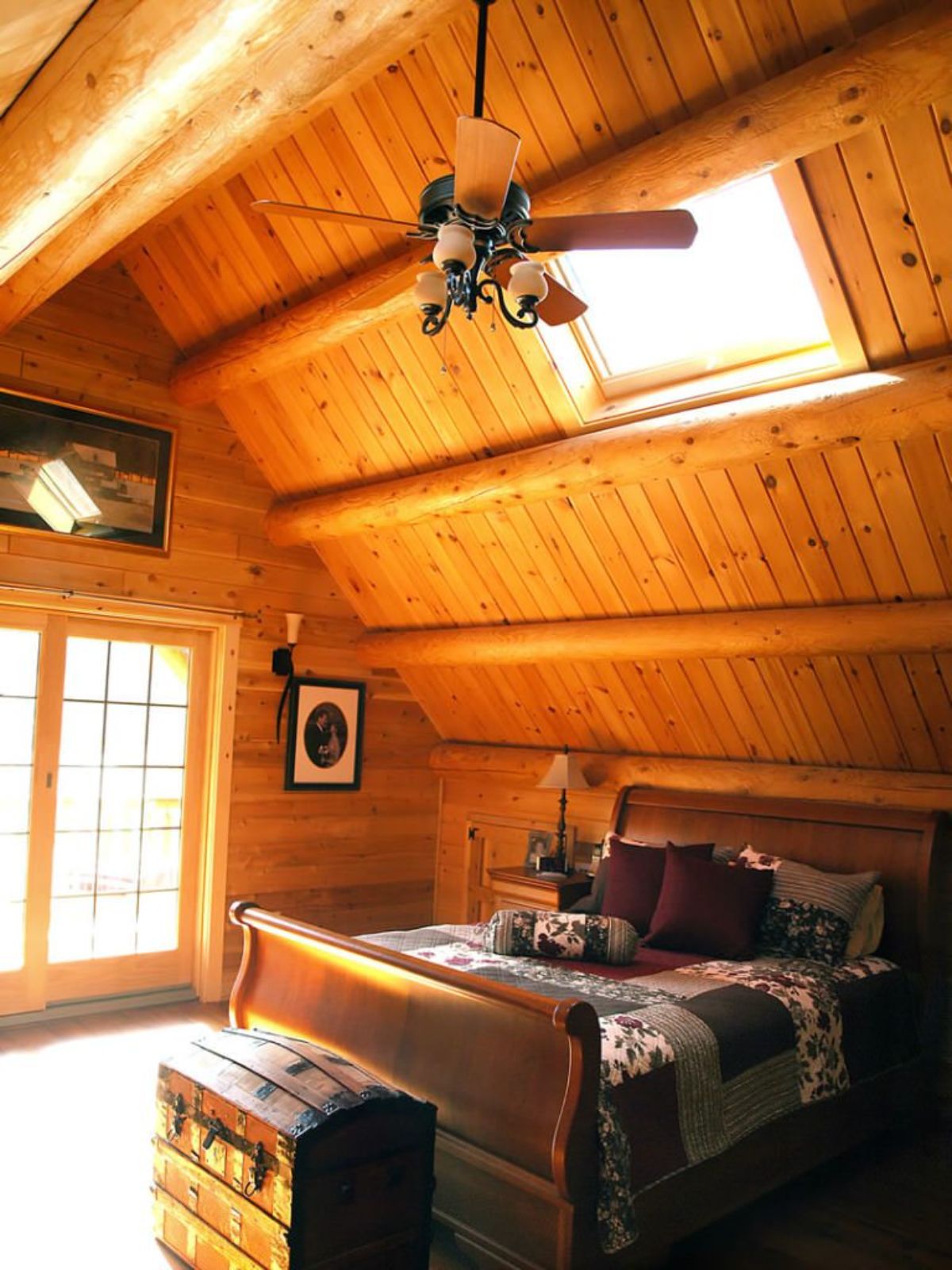 loft in log cabin with sleigh bed under ceiling fan