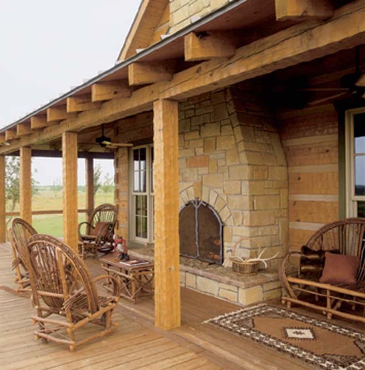 fireplace on deck under cover with whicker chairs around edge of patio