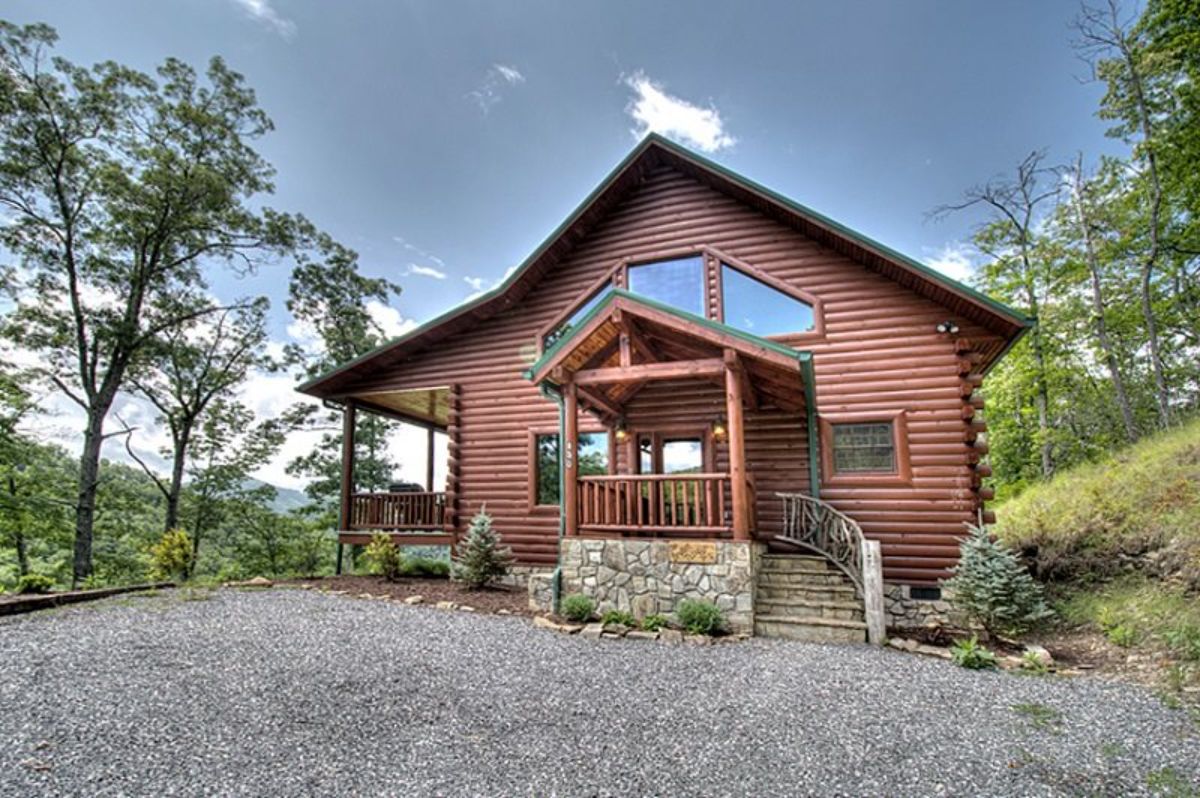 front entry to log cabin with rock base and steps