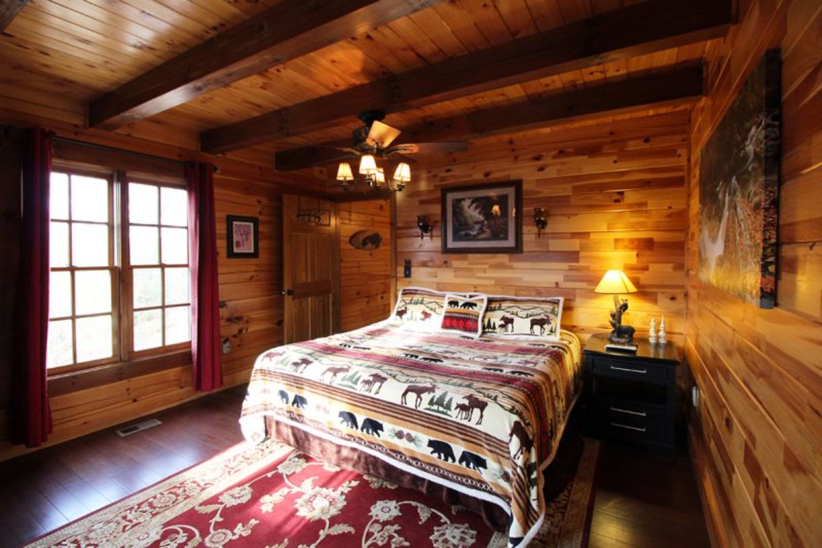 rustic bedding on bed in darker log cabin bedroom