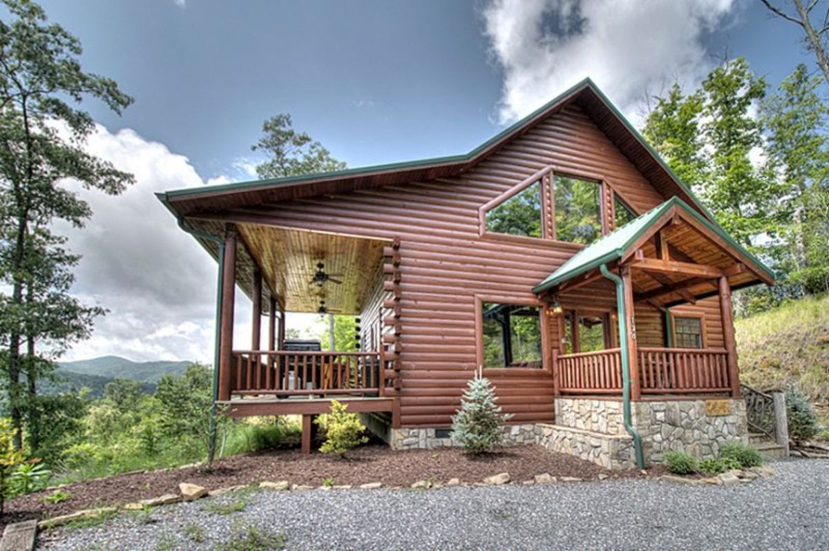 side of log cabin showing windows and open porch on back