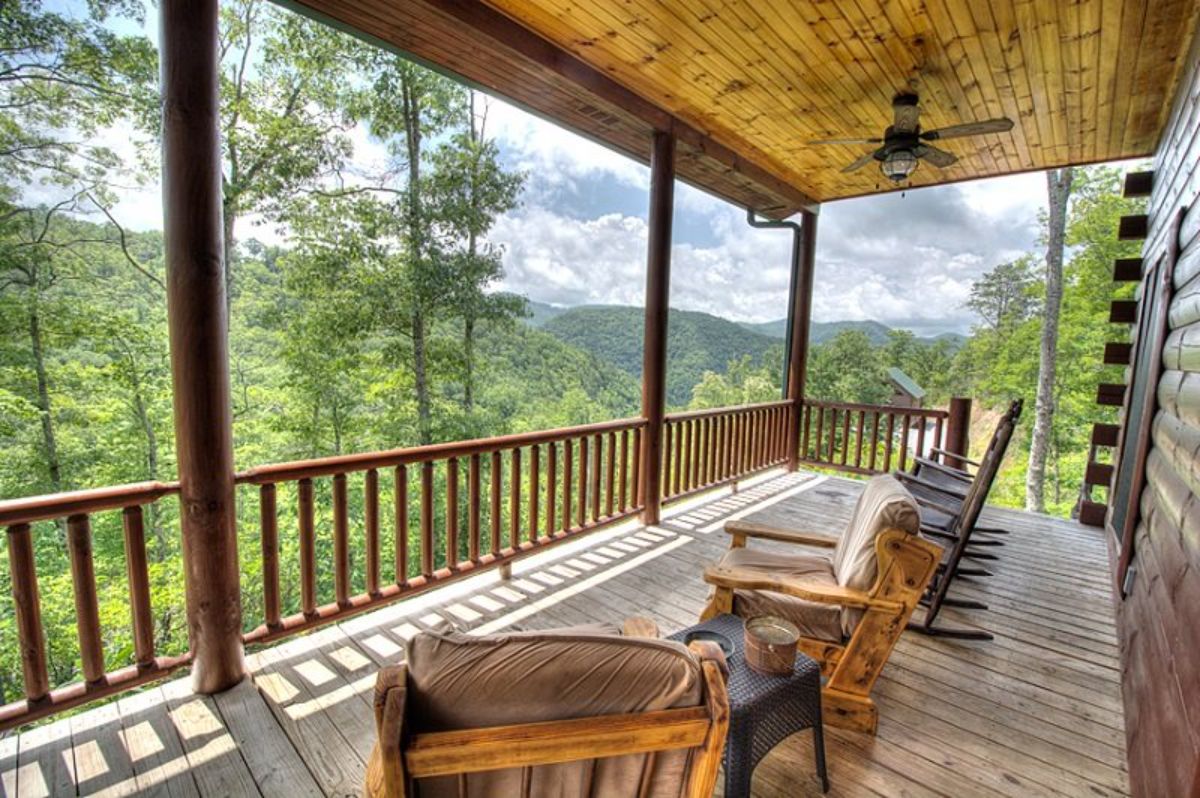 chairs along covered deck on back of log cabin